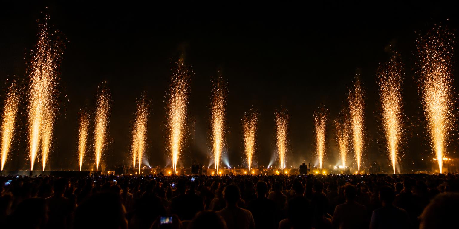 Event crowd with tall golden spark effects at night
